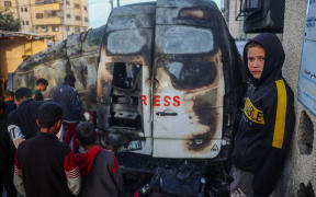 Children check the site of an Israeli strike on a broadcast truck, in the Nuseirat refugee camp in the central Gaza Strip, on December 26, 2024. - A Palestinian TV channel affiliated with the militant group Islamic Jihad said five of its journalists were killed on December 26, in an Israeli strike on their vehicle, with Israel's military saying it had targeted a "terrorist cell". A missile hit the journalists' broadcast truck as it was parked in the Nuseirat camp in central Gaza, according to a statement from their employer, Al-Quds Today. (Photo by Eyad BABA / AFP)