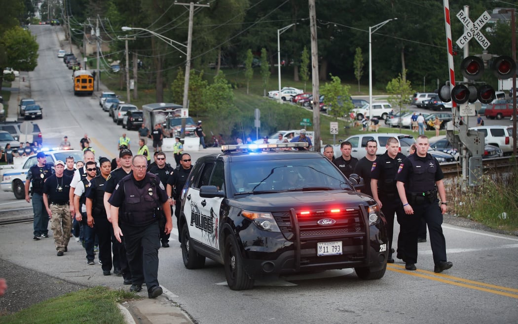 US officers escort the family of police officer Lt. Joe Gliniewicz from a vigil held in his honor in Fox Lake, Illinois.