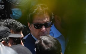 Police commandos escort former Pakistan's Prime Minister Imran Khan as he arrives at the high court in Islamabad