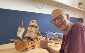 Repair cafe volunteer Pete is fixing a model sailing ship made of matchsticks.