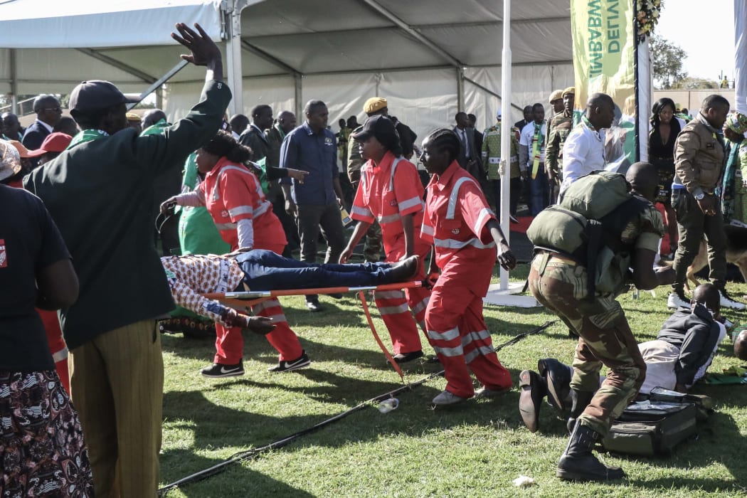 Injured people are evacuated after an explosion at the stadium in Bulawayo where Zimbabwe President just addressed a rally.