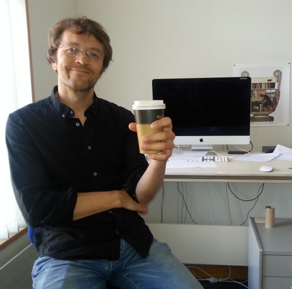 A photo of Alistair Knott in his office after grabbing a cup