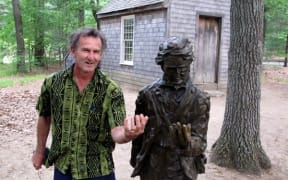 Kennedy Warne standing beside a statue of Henry David Thoreau