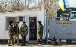 Ukrainian pilots and soldiers gather at the air base entrance in Fedorovka, Saky district, Crimea, on March 22, 2014.