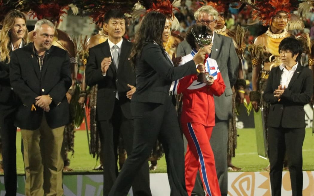 PNG Sports Minister Justin Tkatchenko (L) watches on as North Korea receive the FIFA Under 20 Women's World Cup trophy.