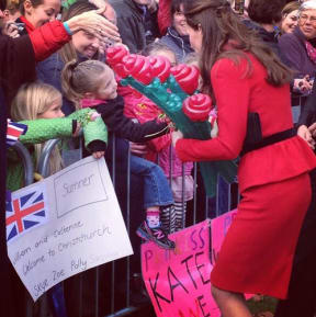 Catherine is given balloon flowers and other presents for baby George.