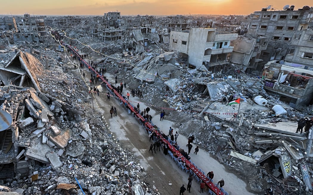 Palestinians gather for a communal iftar, or fast-breaking meal, on the first day of the Muslim holy month of Ramadan, amid building rubble in Rafah in the southern Gaza Strip on March 1, 2025. (Photo by AFP)