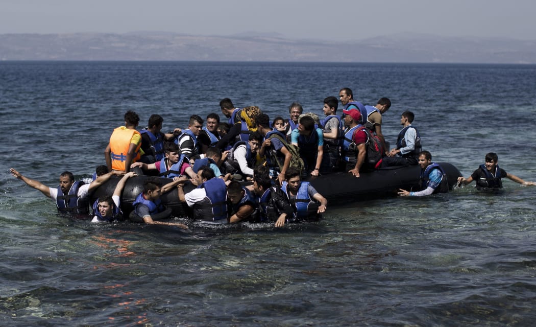 Syrian refugees arrive on the shores of the Greek island of Lesbos after crossing the Aegean Sea from Turkey on a inflatable dinghy.