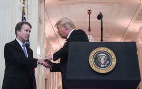 US President Donald Trump shakes hands with Associate Justice of the US Supreme Court Brett Kavanaugh on the back during a ceremonial swear-in at the White House