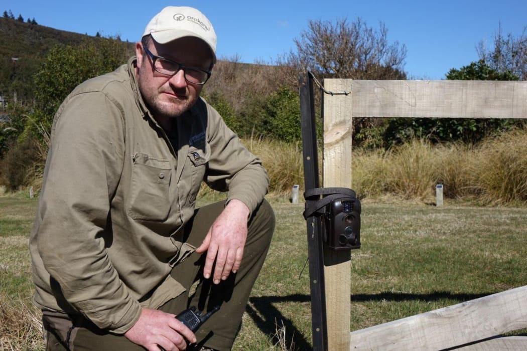 Orokonui's conservation manager, Elton Smith, with one of the motion cameras used to spot the stoat.