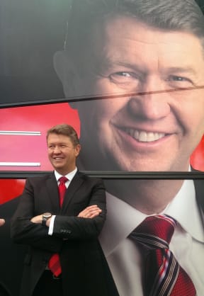 David Cunliffe beside a Labour Party campaign bus.