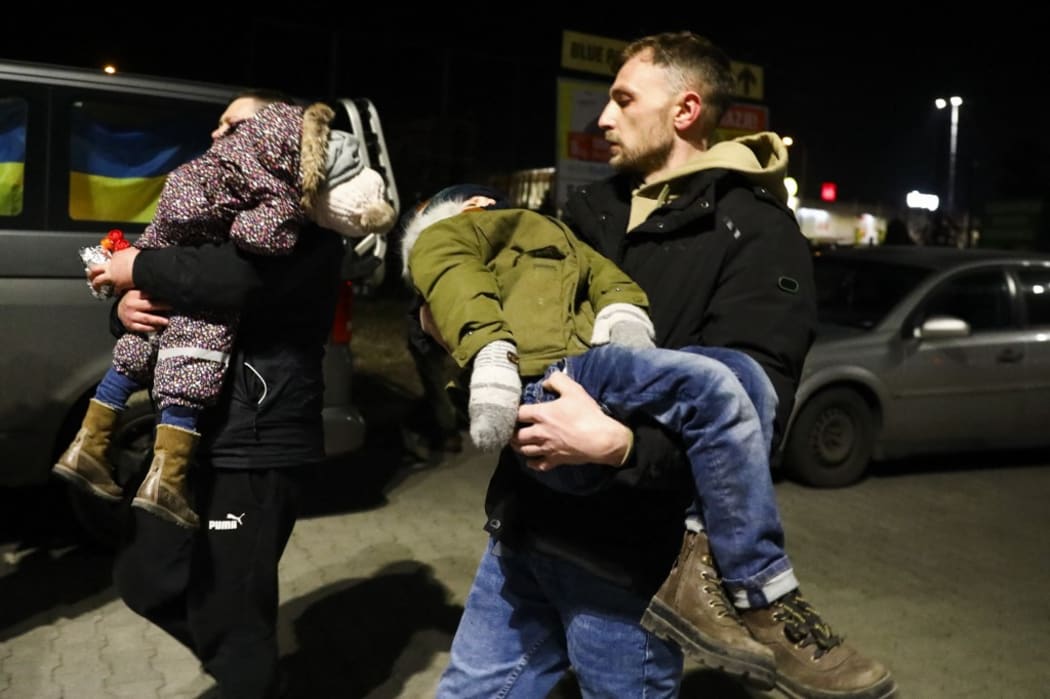 Ukrainians carry babies after arriving with a bus from the Ukrainian-Polish border crossing in Medyka.