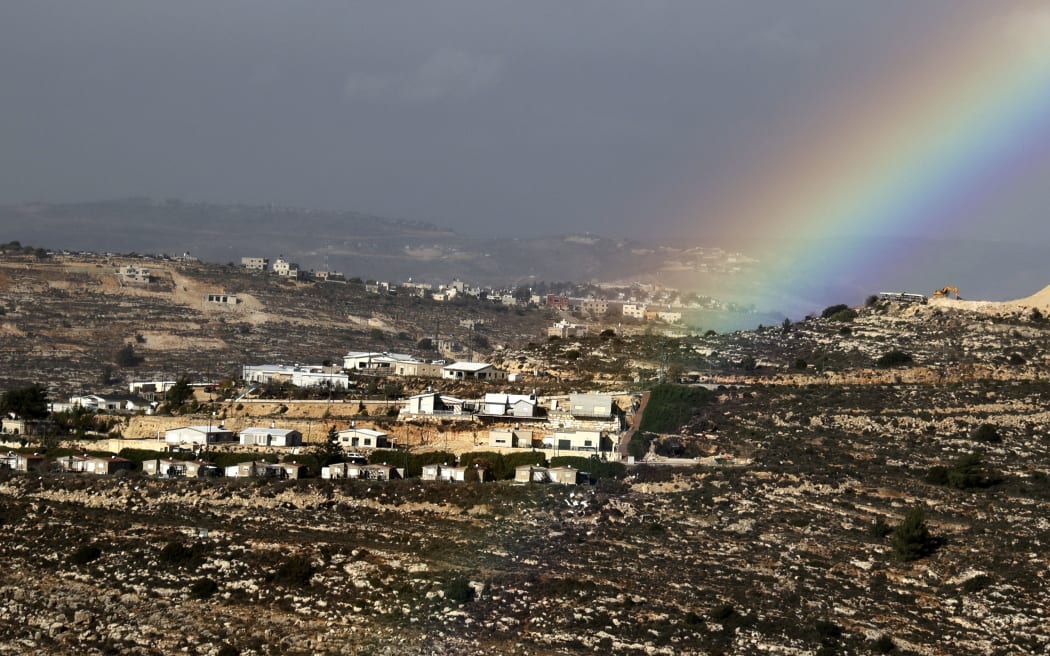 (FILES) This picture taken on December 20, 2021 shows a view of a rainbow in the sky above the Israeli settlement of Eli, south of Nablus in the occupied West Bank. The Israeli government agreed on June 21 on "the immediate advancement of planning for approximately 1000 new residential units" in the settlement, a day after four settlers were shot and killed there following an Israeli army raid in the West Bank which left six Palestinians dead. (Photo by JAAFAR ASHTIYEH / AFP)
