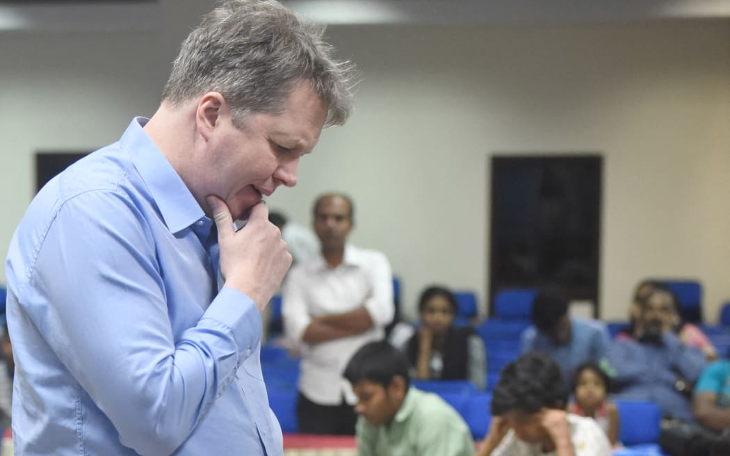 Grandmaster Nigel Short plays chess with a group of players in India