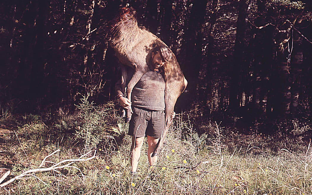 Man with dead deer with no head on back