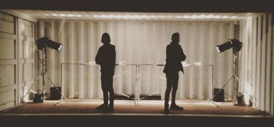 Jim Murphy and Mo Zareei silhouetted in front of their sonic installation, which is housed in a container to keep it out of the weather.