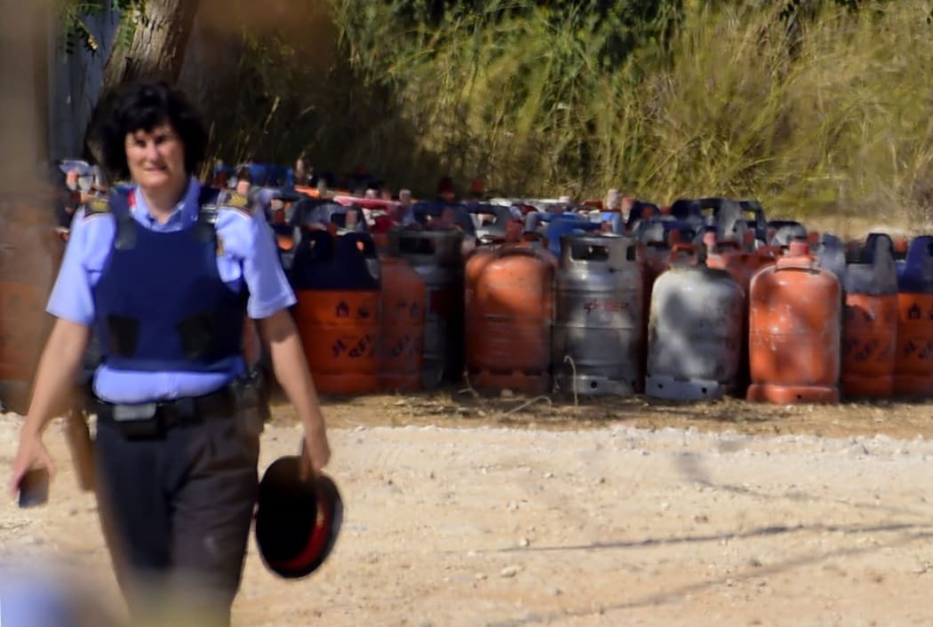 A policewoman in front of dozens of gas bottles in Alcanar during a search linked to the Barcelona and Cambrils attacks.
