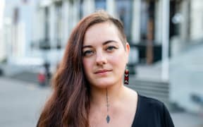 ActionStation Director Kassie Hartendorp stands outside of the Parliament Buildings in Wellington