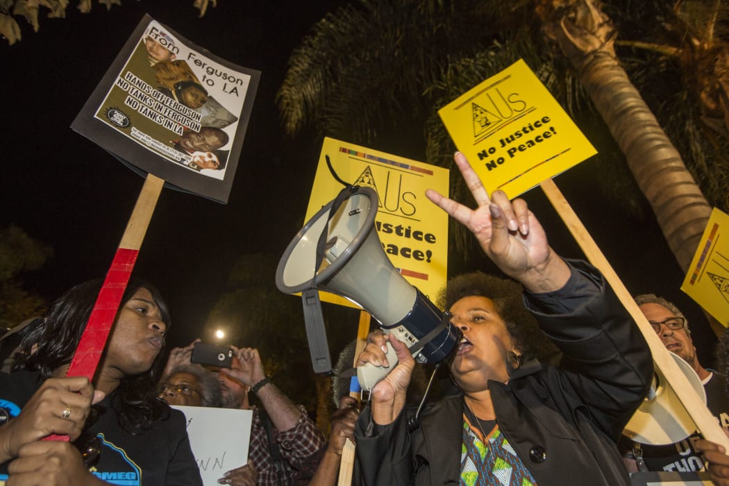 Demonstrators react after a grand jury decided not to indict a white police officer in the Ferguson, Missouri shooting death of an unarmed black teenager, November 24, 2014 in Los Angeles, Calfornia.