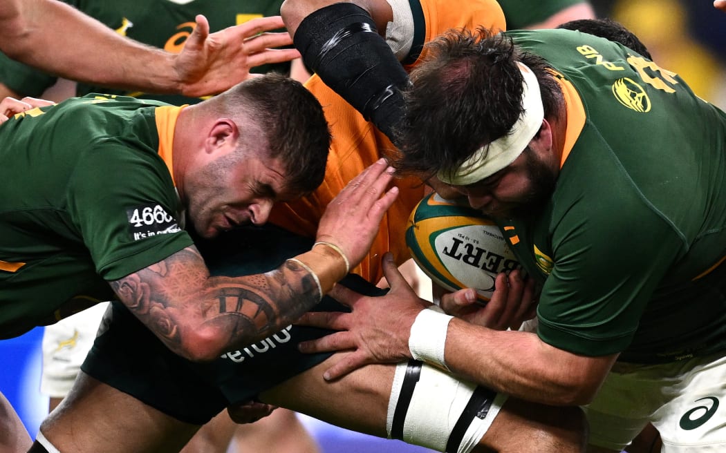 Frans Malherbe of South Africa (right) is tackled by Rory Arnold of Australia.