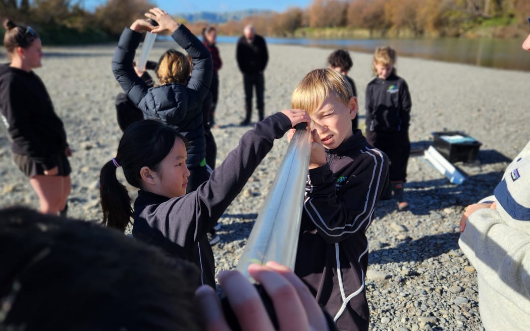 Measuring for water clarity on the banks of the Ruamāhanga