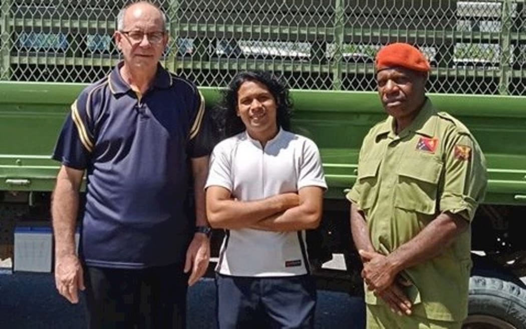 Helal Uddin (centre) is pictured with Father Giorgio Licini (left) and a member of the PNG defence force upon his release.