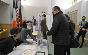 A man wearing a face mask registers for the voting at a pooling station during the Presidential election, in New York.
