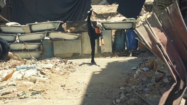 Image of Ahmad dancing among ruins in Damascus
