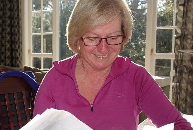 Clare Pinder with papers at a table at home