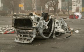 A burned-out automobile is seen on a square near an administrative quarter in central Almaty on January 6, 2022. -