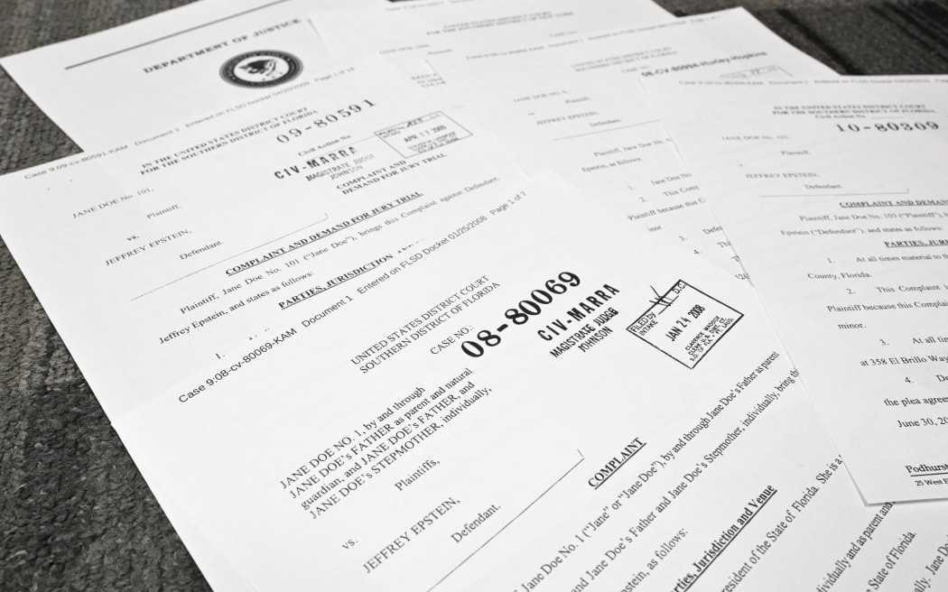 This photo illustration taken in Washington, DC, on December 19, 2025 shows court documents after the US Justice Department began releasing the long-awaited records from the investigation into the politically explosive case of convicted sex offender Jeffrey Epstein. (Photo by Mandel NGAN / AFP)