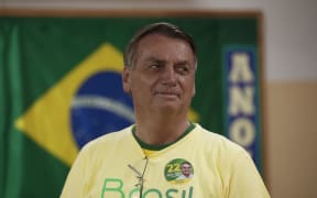 Brazilian President and re-election candidate Jair Bolsonaro looks on as he votes at a polling station in Rio de Janeiro, Brazil, on October 30, 2022, during the presidential run-off election. - After a bitterly divisive campaign and inconclusive first-round vote, Brazil elects its next president in a cliffhanger runoff between far-right incumbent Jair Bolsonaro and veteran leftist Luiz Inacio Lula da Silva. (Photo by BRUNA PRADO / POOL / AFP)