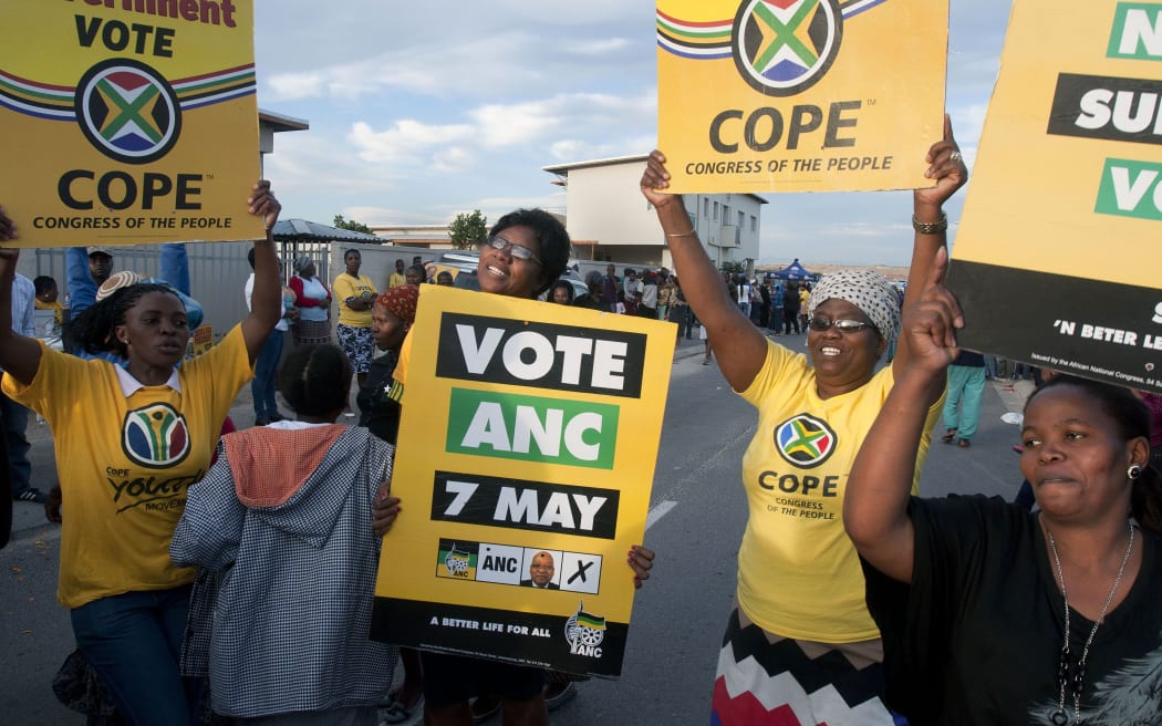 Supporters of rival ANC and Congress of the People (COPE) parties at a Cape Town polling station.