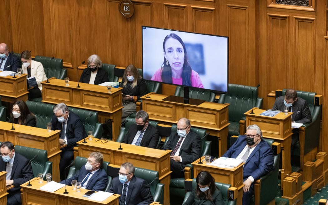 Jacinda Ardern on screen behind National Party caucus