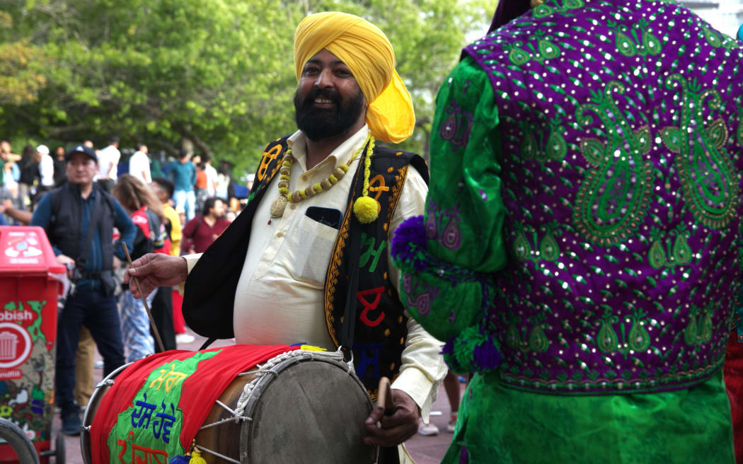 A music performer plays a drum backstage.