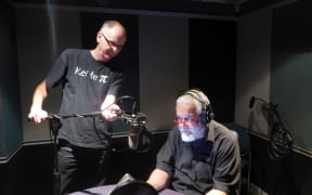 William gets ready to record while his producer makes a fine adjustment to his microphone placement.
