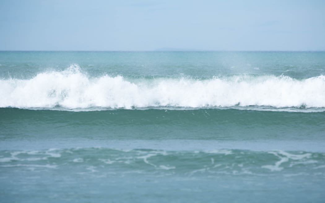 Waves break at a beach.