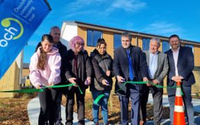 (L-R) is a Ngāi Tūāhuriri whānau member moving into one of their houses, Barry Bragg, Cate Kearney, another whānau member, Chris Bishop, Phil Mauger and Alex Skinner ŌCHT chairperson).
