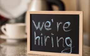 "We're hiring" sign at cafe.