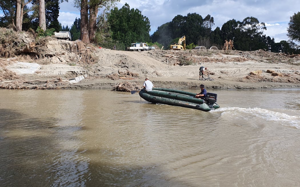 The army green pontoon boat Rissington locals use to ferry essential supplies across the river.