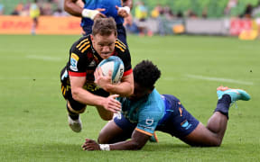 Chiefs' Brad Weber (L) dives over to score a try during the Super Rugby match between Moana Pasifika and the Waikato Chiefs at the AAMI Park in Melbourne on March 4, 2023.