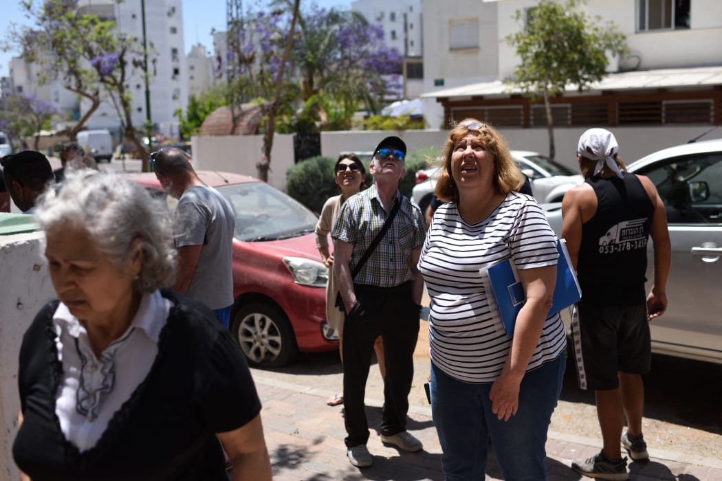 Israelis inspect the damage caused to a building hit by shrapnel from a rocket fired from the Gaza Strip in the Southern city Ashkelon yesterday.