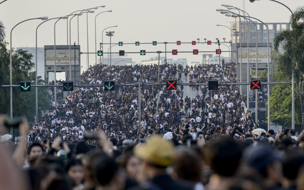 Thai Royalists and well-wishers gather inside Siriraj Hospital while carrying portraits of the King to await the funeral procession.