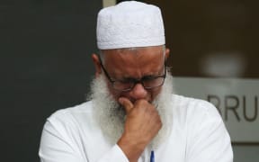 A man reacts as people arrive to pay their respects in front of floral tributes for victims of the March 15 mosque attacks in Christchurch.