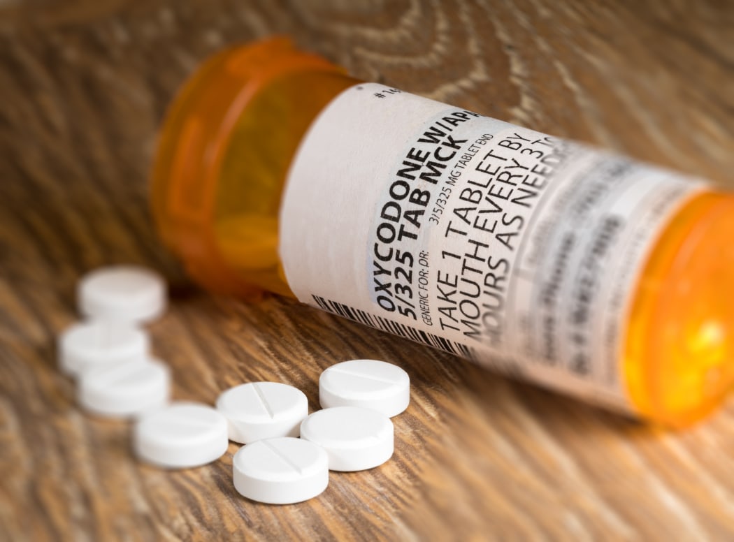 Tiltshift effect of prescription bottle for Oxycodone tablets and pills on wooden table for opioid epidemic illustration