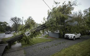 A tree sits against power lines and a home after Storm Fiona hits Nova Scotia in Canada.