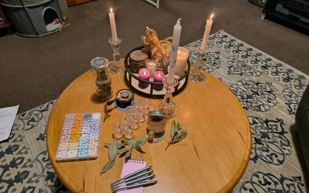 Pagan ritual equipment and candles sit atop a table.