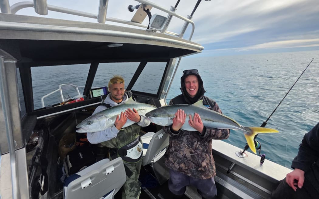 Carlos (left) and Aidan with fish they caught before spotting humpback whales off Kapiti Coast.