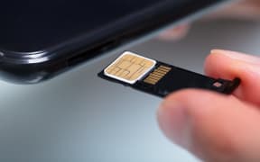 Close-up Of A Person's Hand Inserting Sim Card In Cellphone.