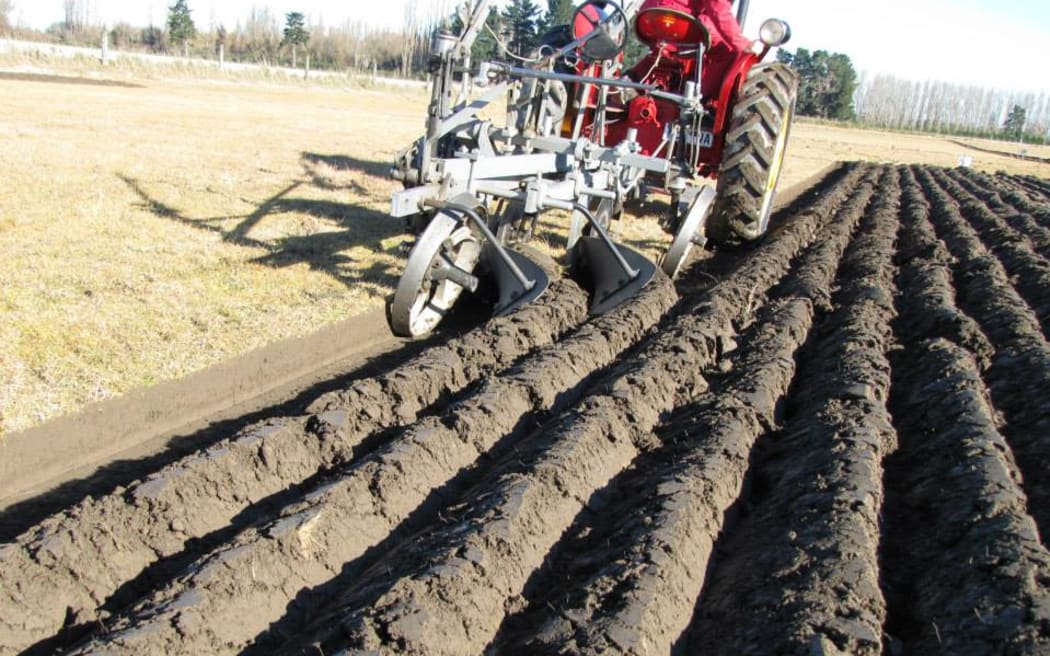 A tractor ploughing the ground.